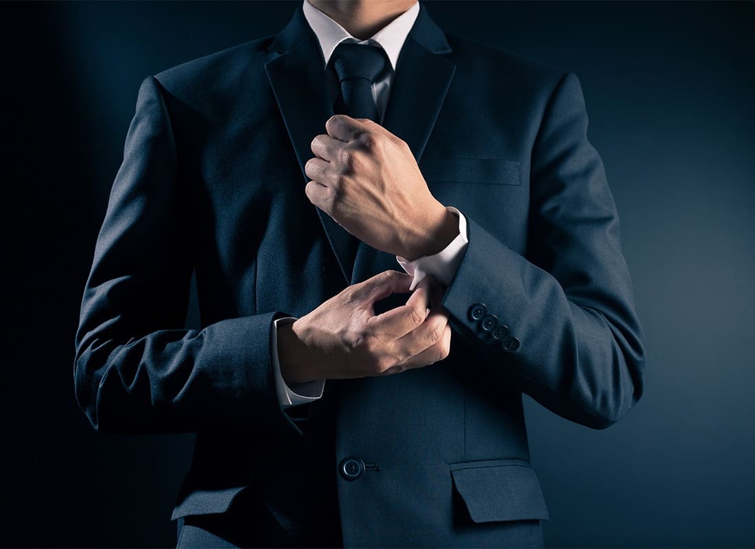Business Insurance - Businessman Fixing Cufflinks on His Suit